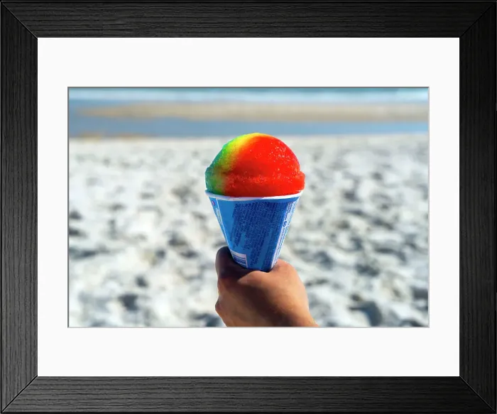 Framed Print : USA, New York, Long Island, Jones Beach, hand holding a colorful snow cone with the beach and ocean in the background Framed Print : USA, New York, Long Island, Jones Beach, hand holding a colorful snow cone with the beach and ocean in the background