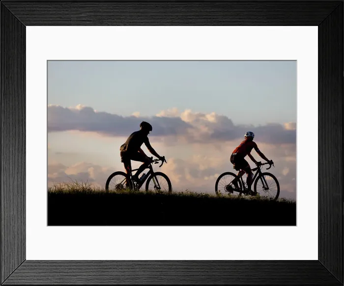 Framed Print : Two cyclists silhouetted at sunset