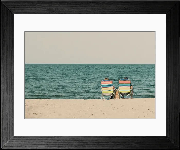 Framed Print : Couple at the beach sitting on beach chairs Framed Print : Couple at the beach sitting on beach chairs