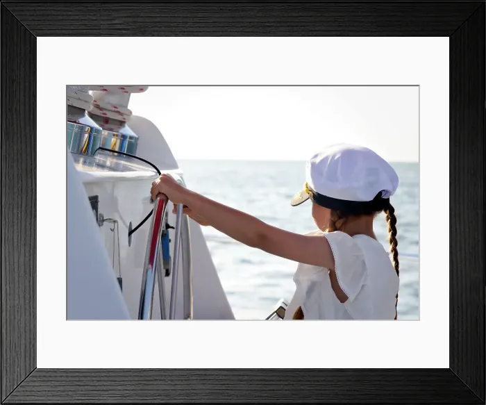 Framed Print : Little girl at helm wearing captain hat