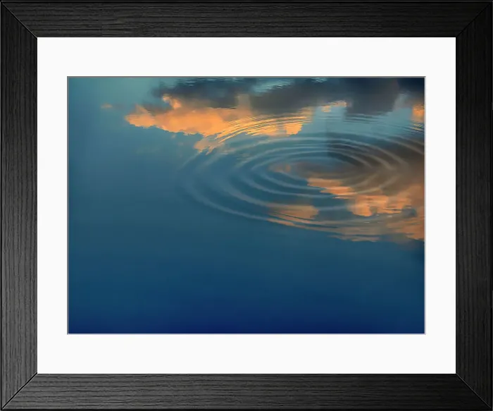 Framed Print : Clouds reflecting over water with concentric ripples