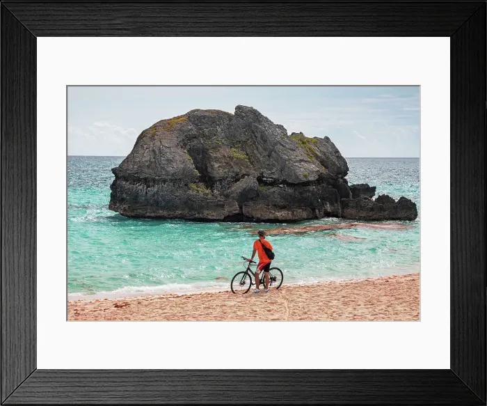 Framed Print : Bermuda, Warwick Long Bay, cyclist standing on beach with aquamarine water and pink sand Framed Print : Bermuda, Warwick Long Bay, cyclist standing on beach with aquamarine water and pink sand