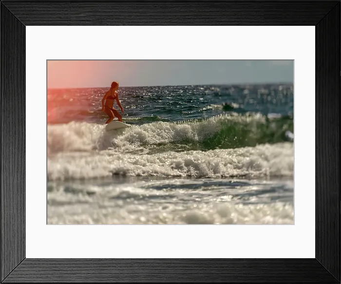 Framed Print : Female surfer riding a wave