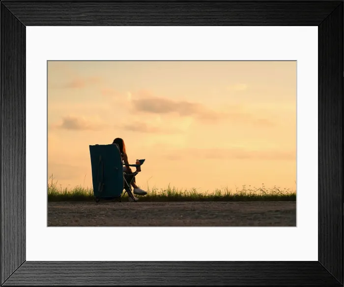 Framed Print : Silhouette of woman sitting at a park at sunset Framed Print : Silhouette of woman sitting at a park at sunset
