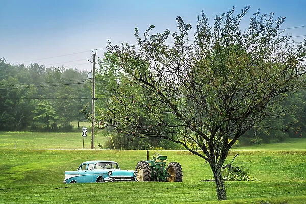 Americana scene, sky blue Chevrolet car next to a John Deer tractor