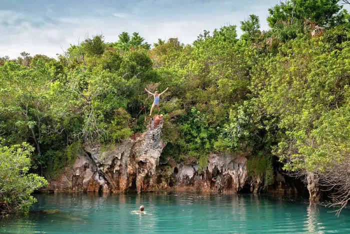 Framed Print : Bermuda, Blue Hole Park, Woman jumping into aquamarine swimming hole