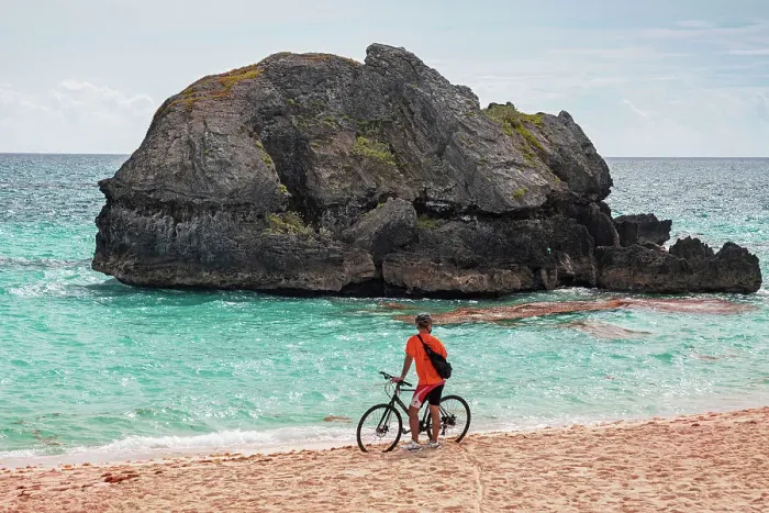 Framed Print : Bermuda, Warwick Long Bay, cyclist standing on beach with aquamarine water and pink sand Framed Print : Bermuda, Warwick Long Bay, cyclist standing on beach with aquamarine water and pink sand