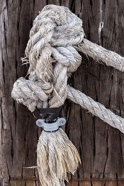Closeup of nautical rope tied to wooden beam