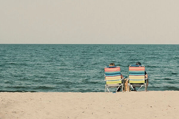 Couple at the beach sitting on beach chairs