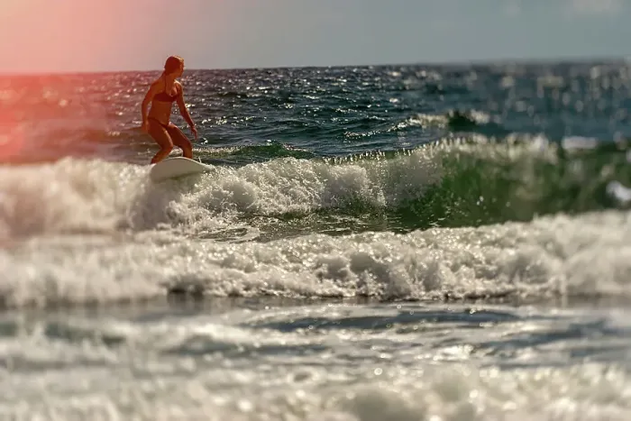 Framed Print : Female surfer riding a wave