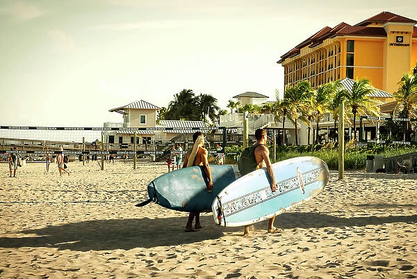 Florida, Deerfield Beach, two surfers walking on beach