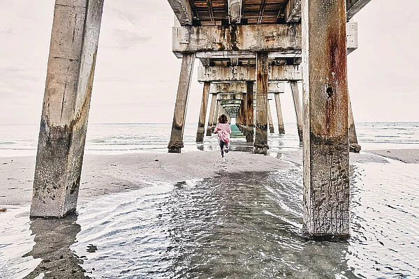 Florida, South Florida, woman running under the Juno beach pier