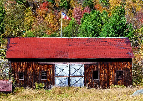 New York, autumn colors with old barn and American flag