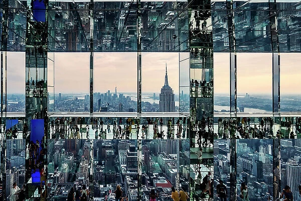 USA, New York City, Manhattan, mirrored view of people walking on glass floor in Summit building, Empire State and lower Manhattan in the background