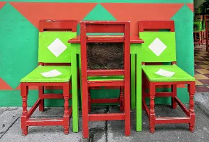 Colombia, Antioquia, Jardin, Traditional colorful chairs at coffee shop
