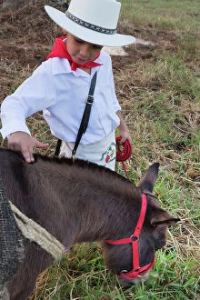 Images Dated 21st July 2019: Colombia, Medellin, Little Boy on Typical Attire Petting a Foal