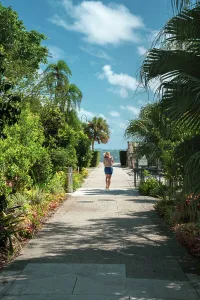 Vertical Prints: Florida, Miami, Villa Vizcaya, woman walking towards water