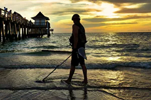 Sunsetting Prints: Florida, Naples, Fishing Pier, beachcombing with metal detector
