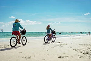 Images Dated 23rd February 2023: Florida, Sarasota, Siesta Key, Couple Bike riding on beach