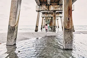 Atlantic Ocean Prints: Florida, South Florida, woman running under the Juno beach pier