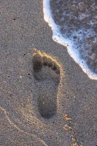 Walker Prints: Footprint on sand with wave