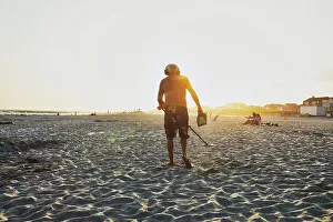 Sunsetting Prints: New York, Long Island, Long Beach, Man with metal detector beachcombing