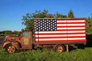 Images Dated 28th June 2017: New York, Long Island, Peconic, rusty truck with American flag on side of road