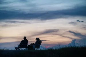 East Coast Prints: Silhouette of couple sitting at a park at sunset