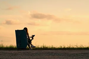 East Coast Prints: Silhouette of woman sitting at a park at sunset