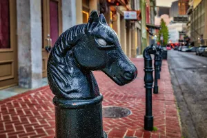 Sidewalk Prints: USA, Louisiana, New Orleans, street scene with horsehead hitching post
