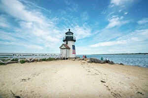 : USA, Nantucket, Massachusetts, Brant Point Lighthouse, people seated on rocks
