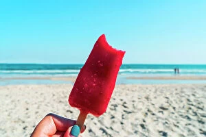 Images Dated 15th July 2022: USA, New York, Long Island, Jones Beach, woman holding a strawberry popsicle with the beach